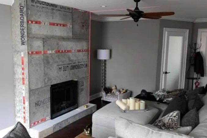 Fireplace wall prepared with cement backer board, aligned with a laser level